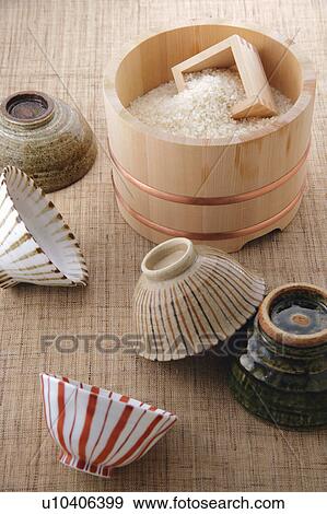 Stock Photo - Uncooked rice in a bamboo tub and rice bowls. Fotosearch