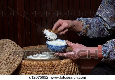 Stock Image - Woman serving white rice. Fotosearch