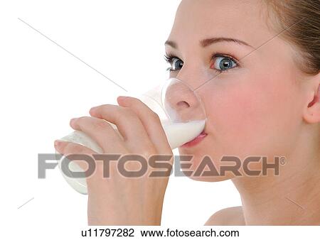 Stock Image - Close-up of a young woman drinking a glass of milk. Fotosearch
