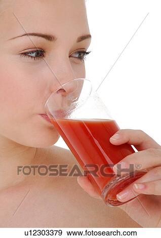 Stock Photo - Close-up of a young woman drinking a glass of juice. Fotosearch