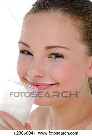 Close-up of a young woman drinking a glass of milk and grinning View Large Photo Image Stock Photo - Close-up of a young woman drinking a glass of milk and grinning. Fotosearch