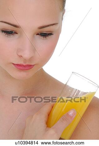 Close-up of a young woman holding a glass of orange juice View Large Photo Image Picture - Close-up of a young woman holding a glass of orange juice. Fotosearch
