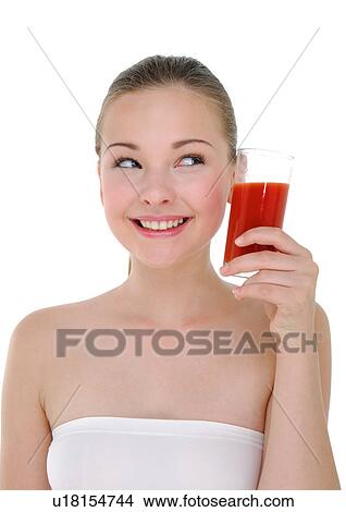 Picture - Close-up of a young woman holding a glass of juice and grining. Fotosearch