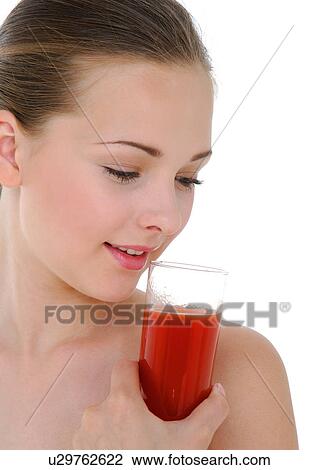 Stock Image - Close-up of a young woman holding a glass of juice. Fotosearch