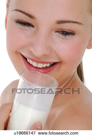 Close-up of a young woman holding a glass of milk and grining View Large Photo Image Stock Photo - Close-up of a young woman holding a glass of milk and grining. Fotosearch