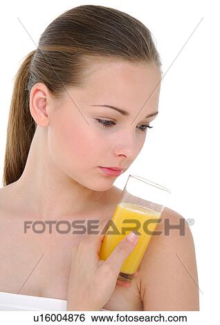 Stock Photograph - Close-up of a young woman holding a glass of orange juice. Fotosearch