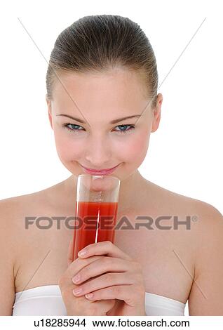 Picture - Portrait of a young woman holding a glass of juice and smiling. Fotosearch