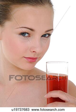 Portrait of a young woman holding a glass of juice View Large Photo Image Stock Image - Portrait of a young woman holding a glass of juice. Fotosearch