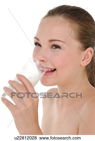 Stock Photo - Side profile of a young woman drinking a glass of milk and smiling. Fotosearch