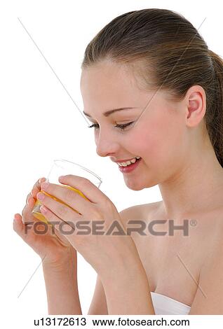 Side profile of a young woman holding a glass of orange juice and grining View Large Photo Image Stock Image - Side profile of a young woman holding a glass of orange juice and grining. Fotosearch