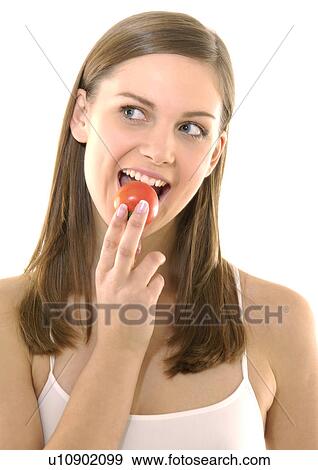 Close-up of a young woman eating a tomato View Large Photo Image Stock Photo - Close-up of a young woman eating a tomato. Fotosearch