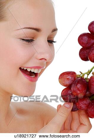 Stock Photo - Close-up of a young woman holding a bunch of red grapes. Fotosearch