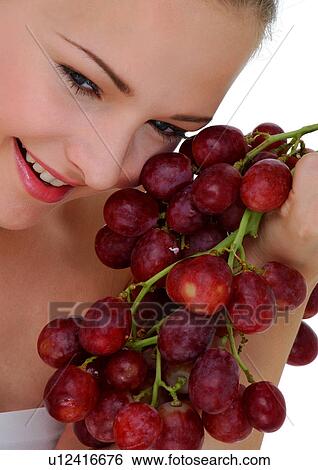 Close-up of a young woman holding a bunch of red grapes View Large Photo Image Stock Photograph - Close-up of a young woman holding a bunch of red grapes. Fotosearch