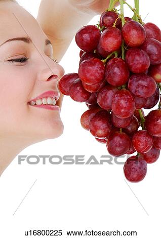 Stock Photography - Close-up of a young woman holding a bunch of red grapes. Fotosearch
