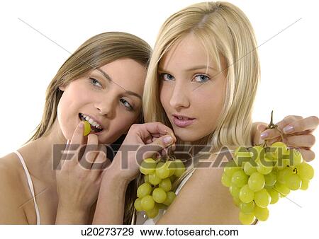 Stock Photo - Close-up of two young women holding bunches of grapes. Fotosearch