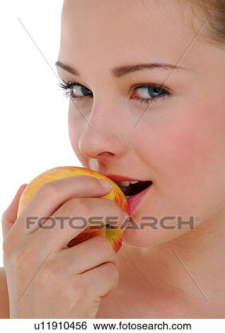 Portrait of a young woman eating an apple View Large Photo Image Stock Photograph - Portrait of a young woman eating an apple. Fotosearch
