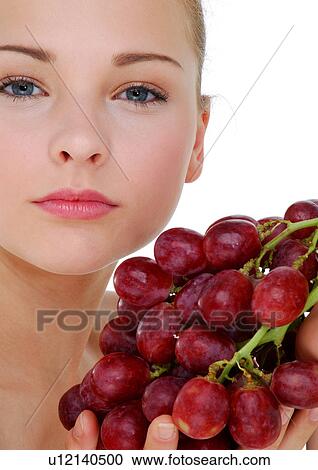 Portrait of a young woman holding a bunch of red grapes View Large Photo Image Stock Image - Portrait of a young woman holding a bunch of red grapes. Fotosearch
