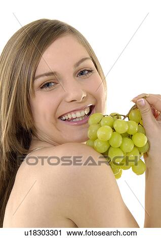 Portrait of a young woman holding a bunch of grapes and grining View Large Photo Image Stock Image - Portrait of a young woman holding a bunch of grapes and grining. Fotosearch