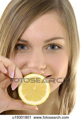 Portrait of a young woman holding a cross section of a lime View Large Photo Image Stock Image - Portrait of a young woman holding a cross section of a lime. Fotosearch