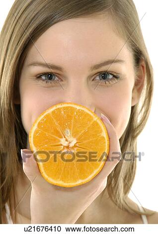 Portrait of a young woman holding a cross section of a orange View Large Photo Image Stock Image - Portrait of a young woman holding a cross section of a orange. Fotosearch