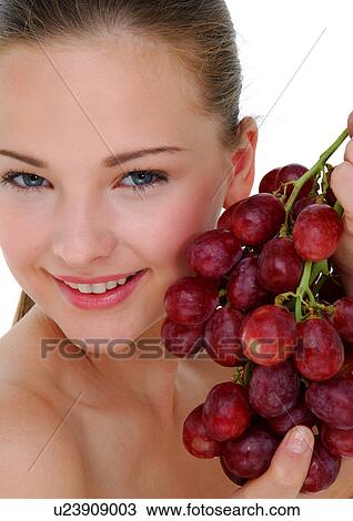 Portrait of a young woman holding a bunch of red grapes and grining View Large Photo Image Stock Image - Portrait of a young woman holding a bunch of red grapes and grining. Fotosearch