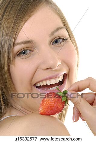 Portrait of a young woman holding a strawberry and grining View Large Photo Image Stock Photo - Portrait of a young woman holding a strawberry and grining. Fotosearch