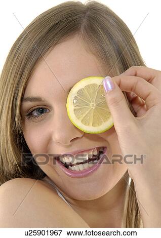 Portrait of a young woman holding a slice of lime and grining View Large Photo Image Stock Photo - Portrait of a young woman holding a slice of lime and grining. Fotosearch