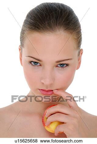Stock Photo - Portrait of a young woman holding an apple and thinking. Fotosearch