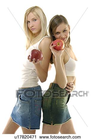 Stock Image - Portrait of two young women holding apples. Fotosearch