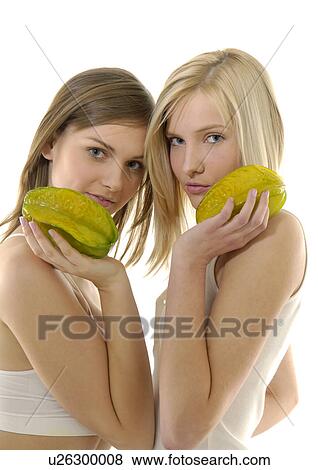 Stock Photo - Portrait of two young women holding starfruits. Fotosearch