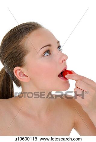 Close-up of a young woman eating a cherry tomato View Large Photo Image Stock Photo - Close-up of a young woman eating a cherry tomato. Fotosearch