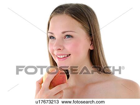 Stock Image - Close-up of a young woman holding a peach and smiling. Fotosearch