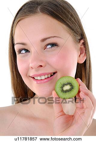 Close-up of a young woman holding a half kiwi fruit View Large Photo Image Stock Photo - Close-up of a young woman holding a half kiwi fruit. Fotosearch
