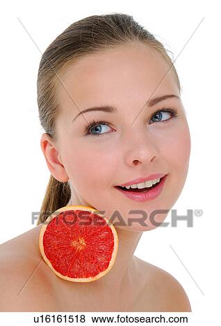 Close-up of a young woman holding a half grapefruit View Large Photo Image Stock Photo - Close-up of a young woman holding a half grapefruit. Fotosearch