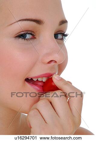 Portrait of a young woman eating a cherry tomato View Large Photo Image Stock Image - Portrait of a young woman eating a cherry tomato. Fotosearch