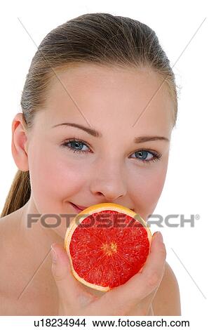 Picture - Portrait of a young woman holding a half grapefruit. Fotosearch
