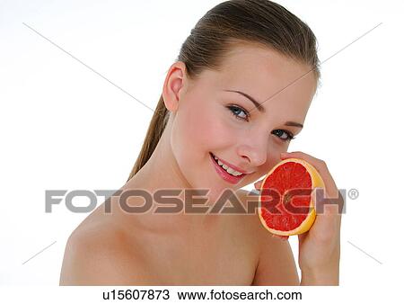 Portrait of a young woman holding a half grapefruit View Large Photo Image Stock Image - Portrait of a young woman holding a half grapefruit. Fotosearch