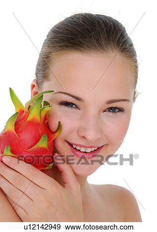 Stock Photo - Portrait of a young woman holding a pitaya fruit on her shoulder and smiling. Fotosearch