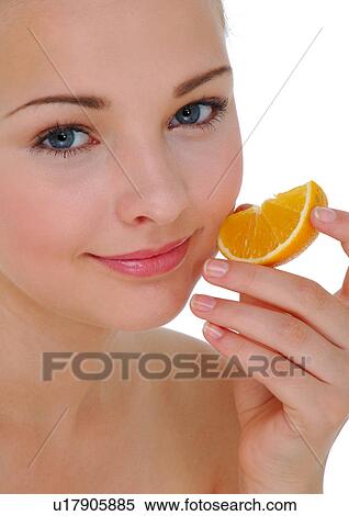 Portrait of a young woman holding a slice of orange View Large Photo Image Stock Photography - Portrait of a young woman holding a slice of orange. Fotosearch