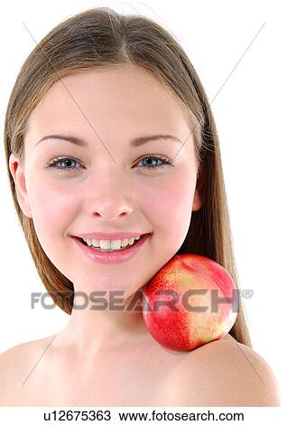 Stock Image - Portrait of a young woman with a peach on her shoulder. Fotosearch