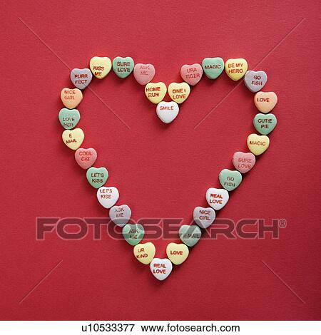 Colorful candy hearts with sayings on them arranged in shape of heart on red background. View Large Photo Image Stock Photo - Colorful candy hearts with sayings on them arranged in shape of heart on red background.. Fotosearch