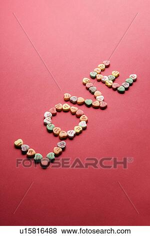 Stock Photo - Colorful candy hearts with sayings on them arranged to spell the word love.. Fotosearch