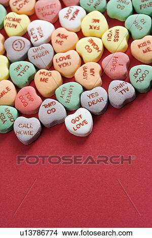 Group of colorful candy hearts with sayings on them arranged on red background. View Large Photo Image Picture - Group of colorful candy hearts with sayings on them arranged on red background.. Fotosearch