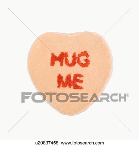 Stock Photo - Orange candy heart that reads hug me against white background.. Fotosearch
