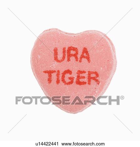 Stock Image - Pink candy heart that reads URA tiger against white background.. Fotosearch