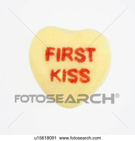 Yellow candy heart that reads first kiss against white background. View Large Photo Image Stock Image - Yellow candy heart that reads first kiss against white background.. Fotosearch