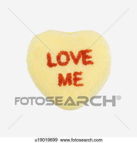Yellow candy heart that reads love me against white background. View Large Photo Image Stock Photo - Yellow candy heart that reads love me against white background.. Fotosearch