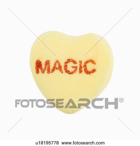 Stock Photo - Yellow candy heart that reads magic against white background.. Fotosearch
