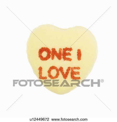 Stock Image - Yellow candy heart that reads one I love against white background.. Fotosearch