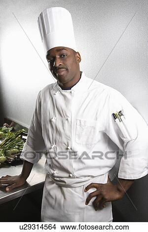 African-American male chef wearing traditional uniform and toque looking at viewer. View Large Photo Image Picture - African-American male chef wearing traditional uniform and toque looking at viewer.. Fotosearch
